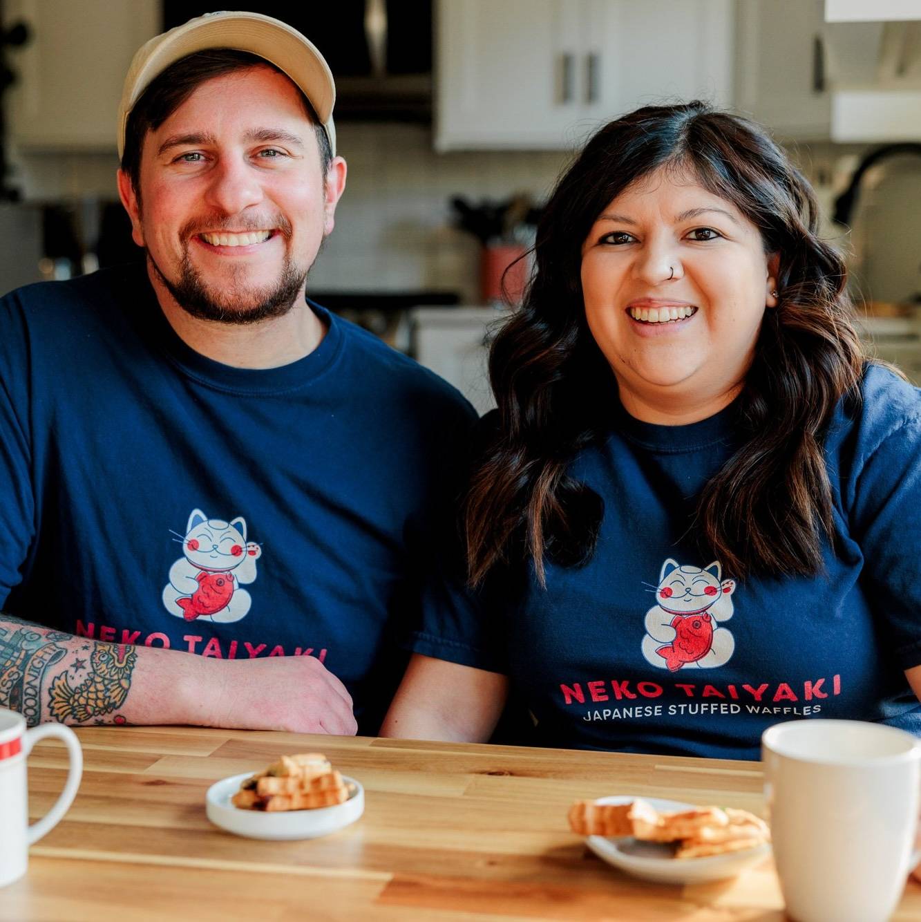Owners smile looking at camera with coffee